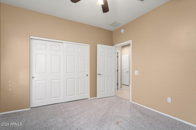 unfurnished bedroom with light carpet, a closet, and ceiling fan