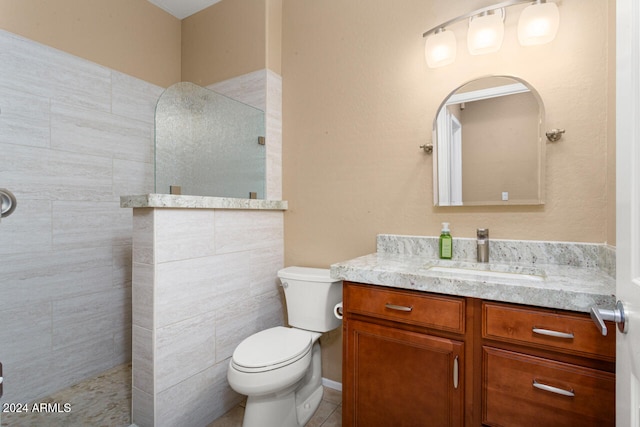 bathroom with vanity, a shower, tile patterned flooring, and toilet