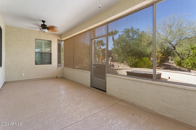 unfurnished sunroom featuring ceiling fan