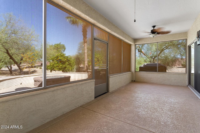 unfurnished sunroom with ceiling fan