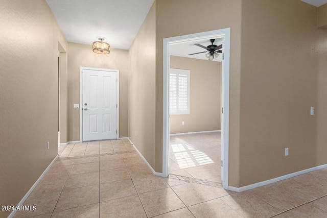 entryway featuring ceiling fan with notable chandelier and light tile patterned flooring