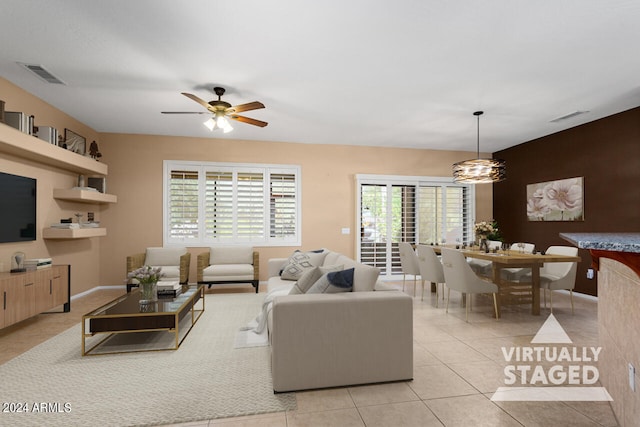 living room with ceiling fan with notable chandelier and light tile patterned flooring