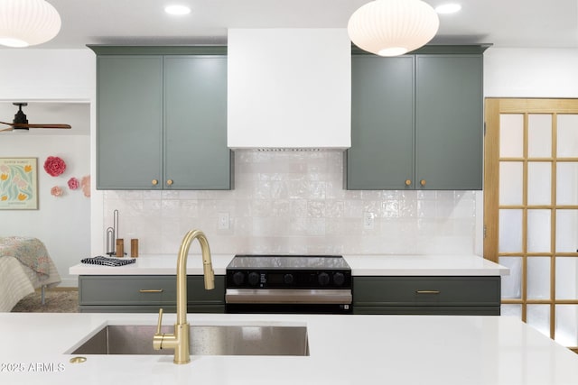 2808 N Steves Blvd, Flagstaff, AZ 86004 - kitchen with range with electric cooktop, wall chimney range hood, green cabinetry, a sink, and light countertops