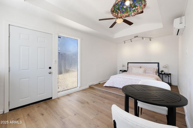 2808 N Steves Blvd, Flagstaff, AZ 86004 - bedroom with a tray ceiling, baseboards, a wall mounted AC, and light wood-type flooring
