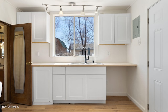 2808 N Steves Blvd, Flagstaff, AZ 86004 - kitchen featuring light countertops, white cabinets, electric panel, a sink, and light wood-type flooring