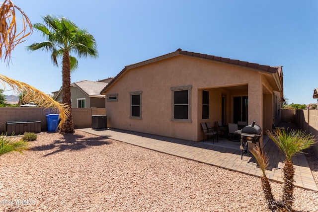 rear view of house featuring central AC unit and a patio area