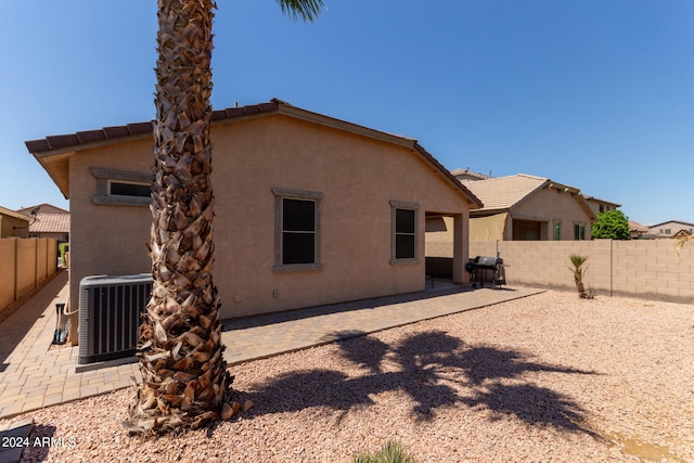 back of property featuring central AC unit and a patio