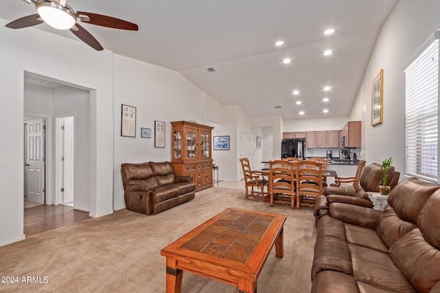 living room featuring light carpet, vaulted ceiling, and ceiling fan