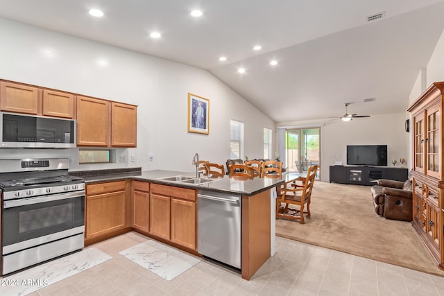 kitchen with ceiling fan, stainless steel appliances, kitchen peninsula, and sink