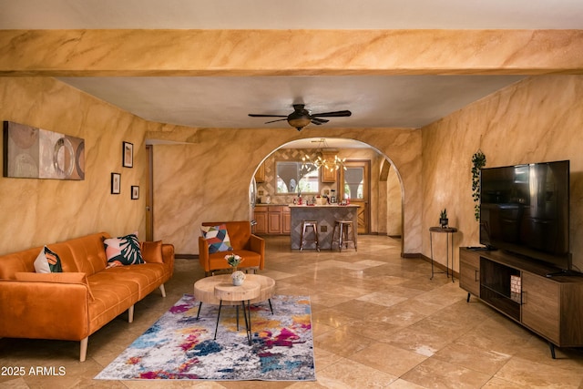 living room with ceiling fan with notable chandelier