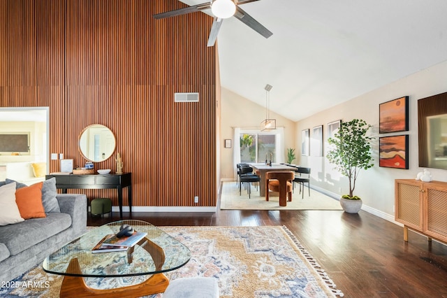 living room featuring ceiling fan, high vaulted ceiling, and dark wood-type flooring