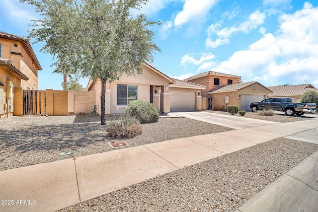 597 S 167th Dr, Goodyear, AZ 85338 - view of front of house featuring concrete driveway, an attached garage, stucco siding, a gate, and a tiled roof