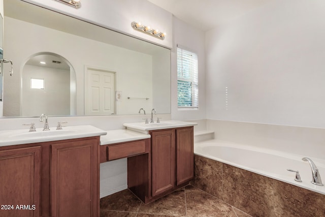 bathroom featuring vanity, tiled bath, and tile patterned floors