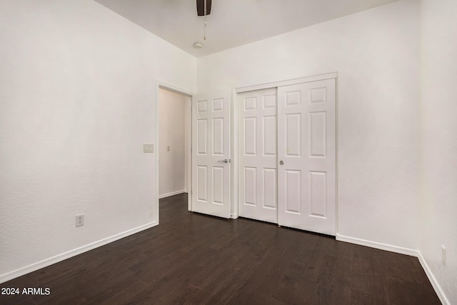 unfurnished bedroom with dark hardwood / wood-style floors, ceiling fan, and a closet