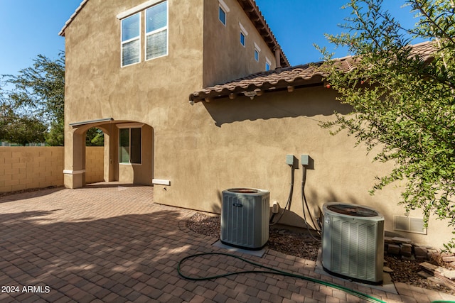 rear view of property with central air condition unit and a patio