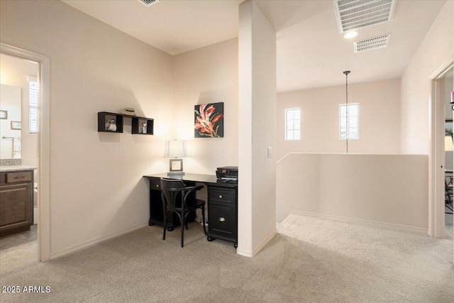 office with baseboards, visible vents, and light colored carpet