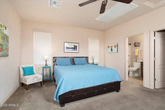 carpeted bedroom featuring baseboards, visible vents, a ceiling fan, and ensuite bathroom