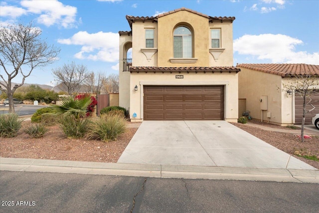 mediterranean / spanish house featuring driveway, a tile roof, a garage, and stucco siding