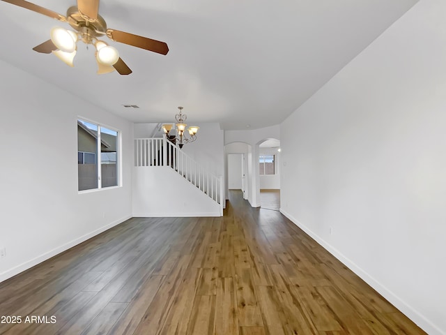 unfurnished living room with wood-type flooring and ceiling fan with notable chandelier