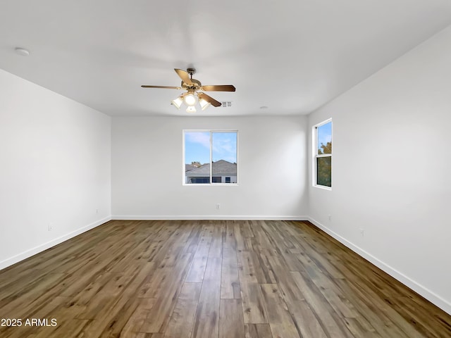 spare room with hardwood / wood-style flooring, ceiling fan, and a healthy amount of sunlight