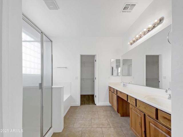 bathroom with tile patterned flooring, plus walk in shower, and vanity