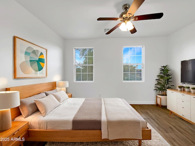 bedroom with dark hardwood / wood-style flooring and ceiling fan