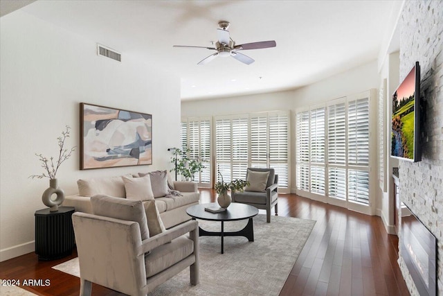 living room featuring ceiling fan, plenty of natural light, and dark wood-type flooring