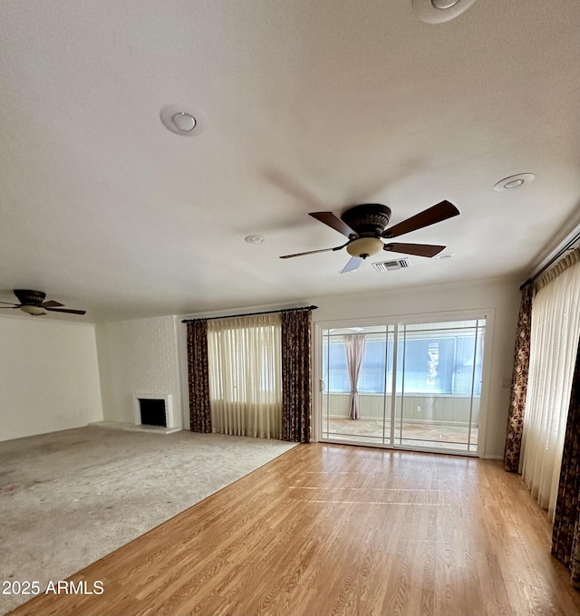 unfurnished living room with ceiling fan and light wood-type flooring