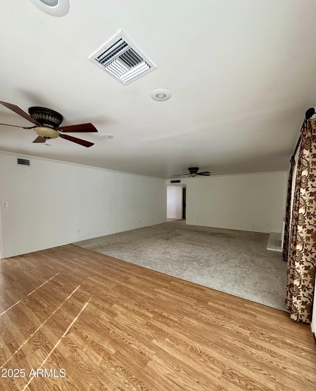 unfurnished living room featuring ceiling fan and light wood-type flooring