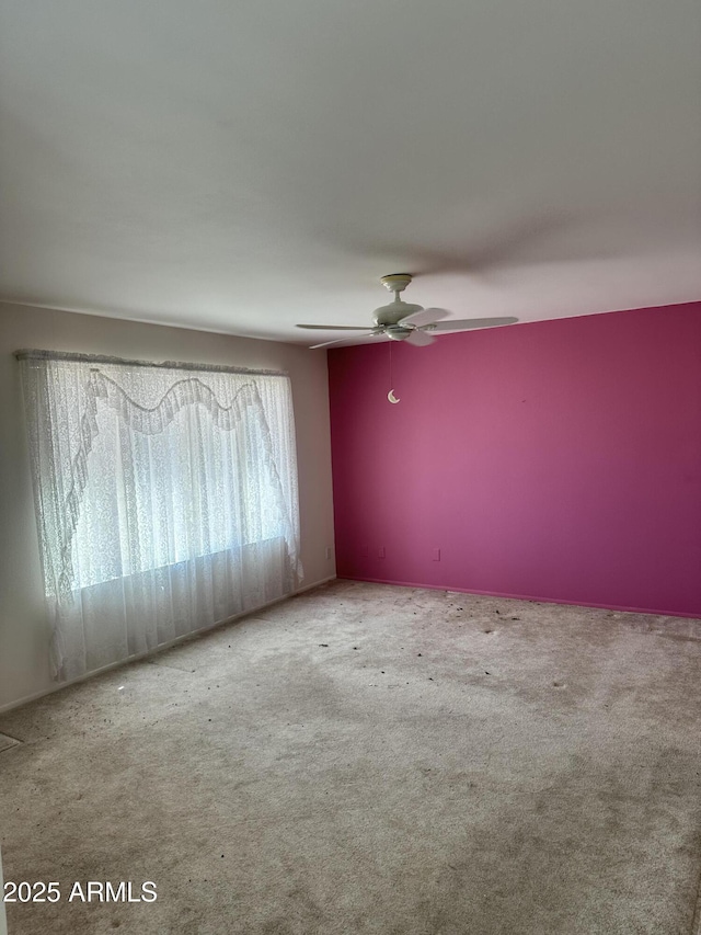 empty room with ceiling fan and carpet flooring