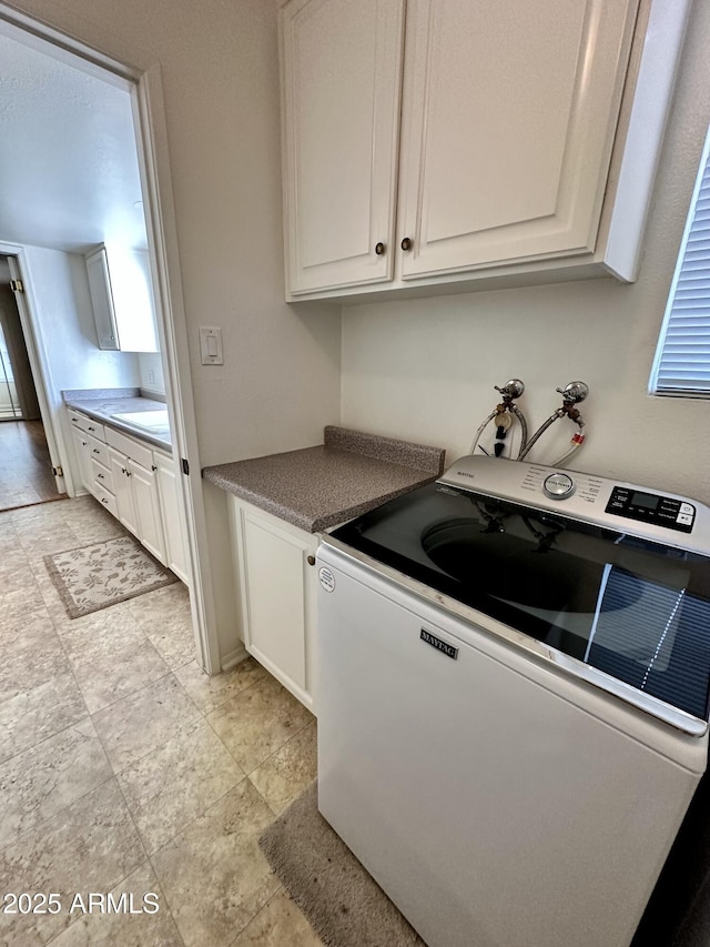 kitchen with white cabinetry and washer / clothes dryer