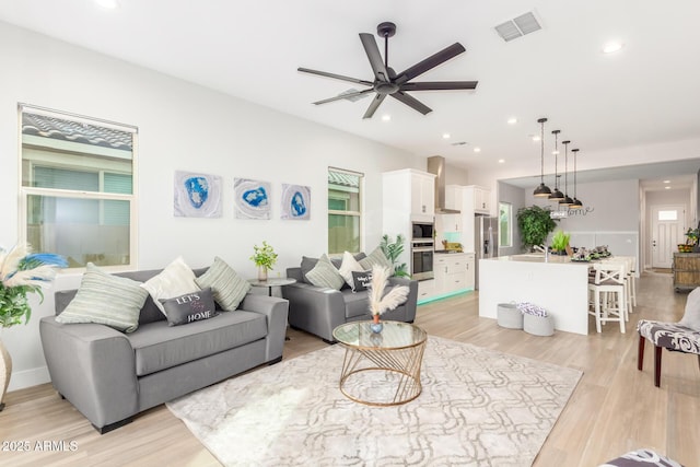 living room featuring a wealth of natural light, recessed lighting, visible vents, and light wood-style flooring