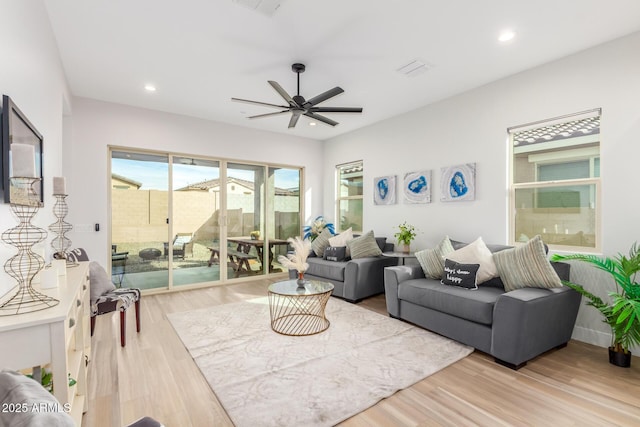 living area with a ceiling fan, recessed lighting, visible vents, and wood finished floors