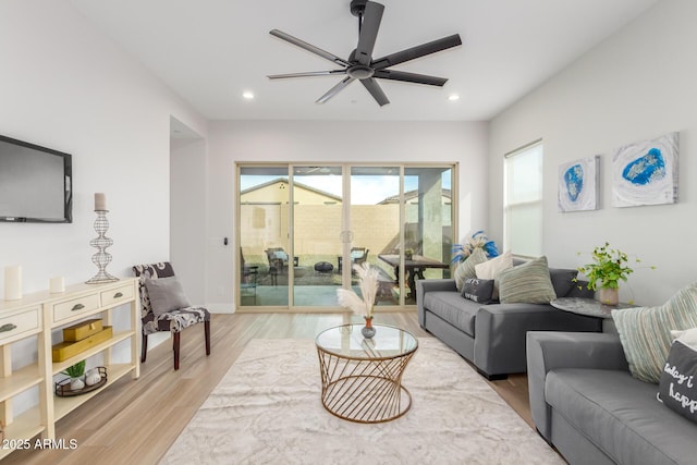 living room with ceiling fan, light wood finished floors, baseboards, and recessed lighting