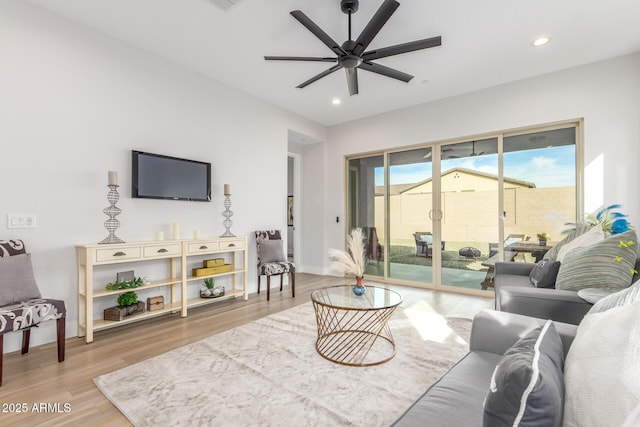 living area with recessed lighting, ceiling fan, baseboards, and wood finished floors