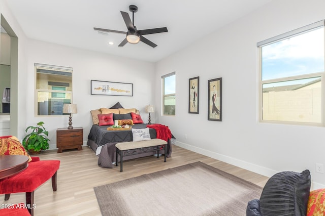 bedroom featuring light wood-style flooring, multiple windows, and baseboards