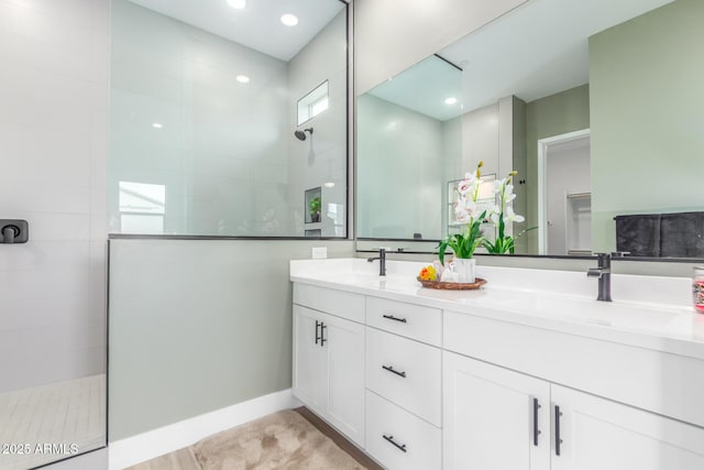 bathroom featuring a sink, double vanity, and walk in shower