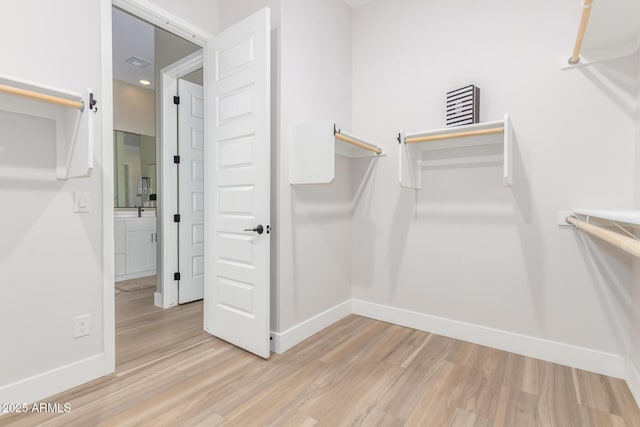 spacious closet featuring light wood-style flooring