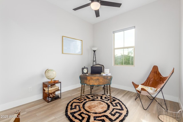 office area with light wood-style flooring, baseboards, and ceiling fan