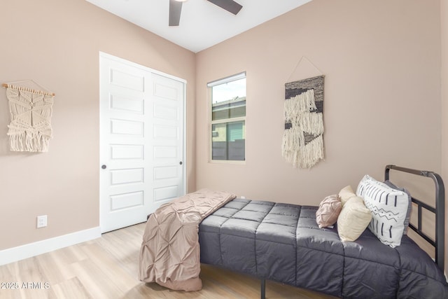 bedroom featuring ceiling fan, light wood-type flooring, and baseboards