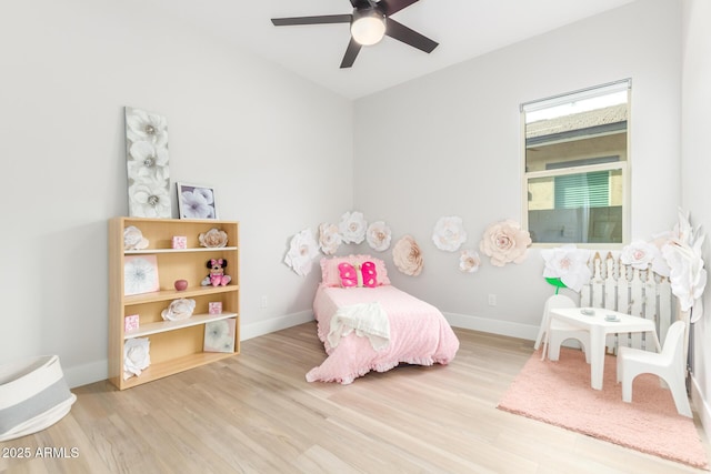 bedroom featuring radiator heating unit, wood finished floors, a ceiling fan, and baseboards