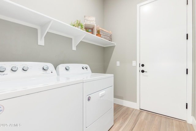 laundry room with laundry area, light wood finished floors, independent washer and dryer, and baseboards