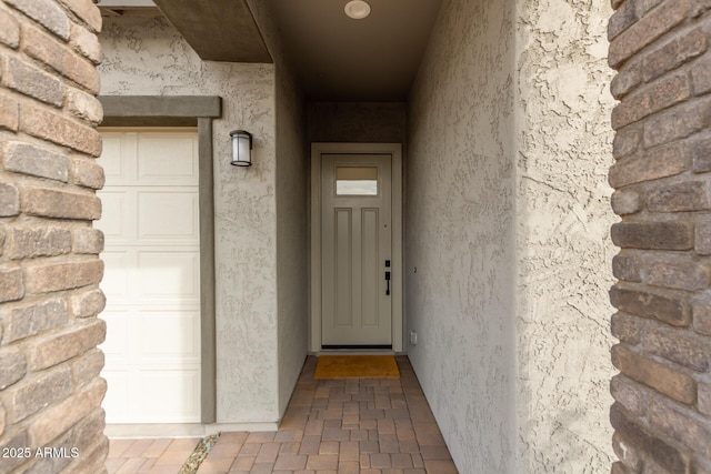 entrance to property featuring stucco siding