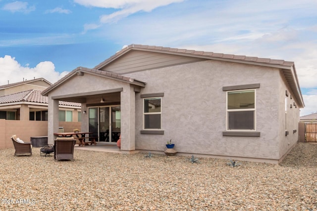 rear view of house featuring ceiling fan, a patio area, fence, and stucco siding