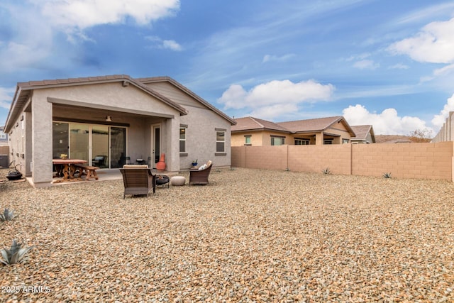 rear view of property featuring a ceiling fan, a patio area, fence, and stucco siding