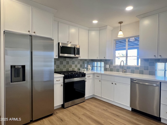 kitchen with stainless steel appliances, sink, and white cabinets