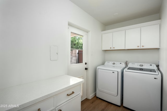 laundry area featuring cabinets, dark hardwood / wood-style flooring, and washing machine and clothes dryer