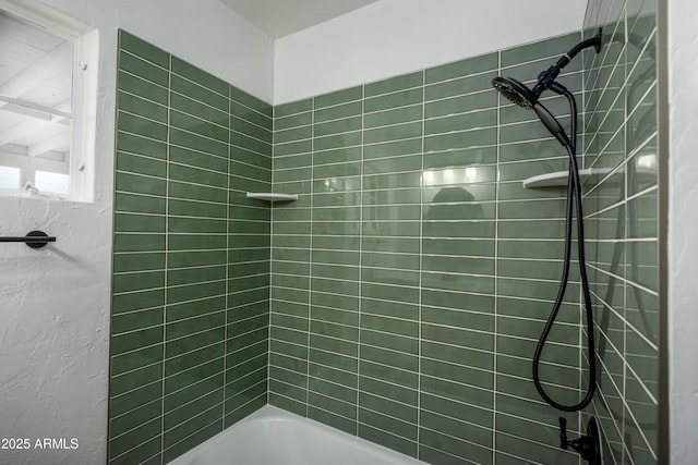 bathroom featuring tiled shower / bath