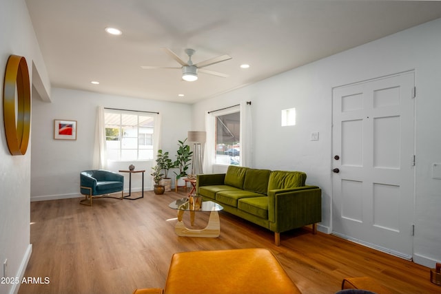 living room featuring ceiling fan and light hardwood / wood-style floors