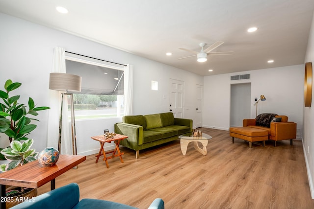 living room featuring ceiling fan and light hardwood / wood-style floors